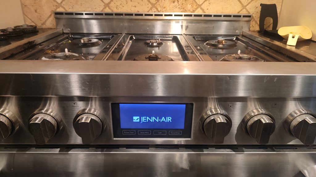 JennAir gas range with front control display and cooktop burners visible.