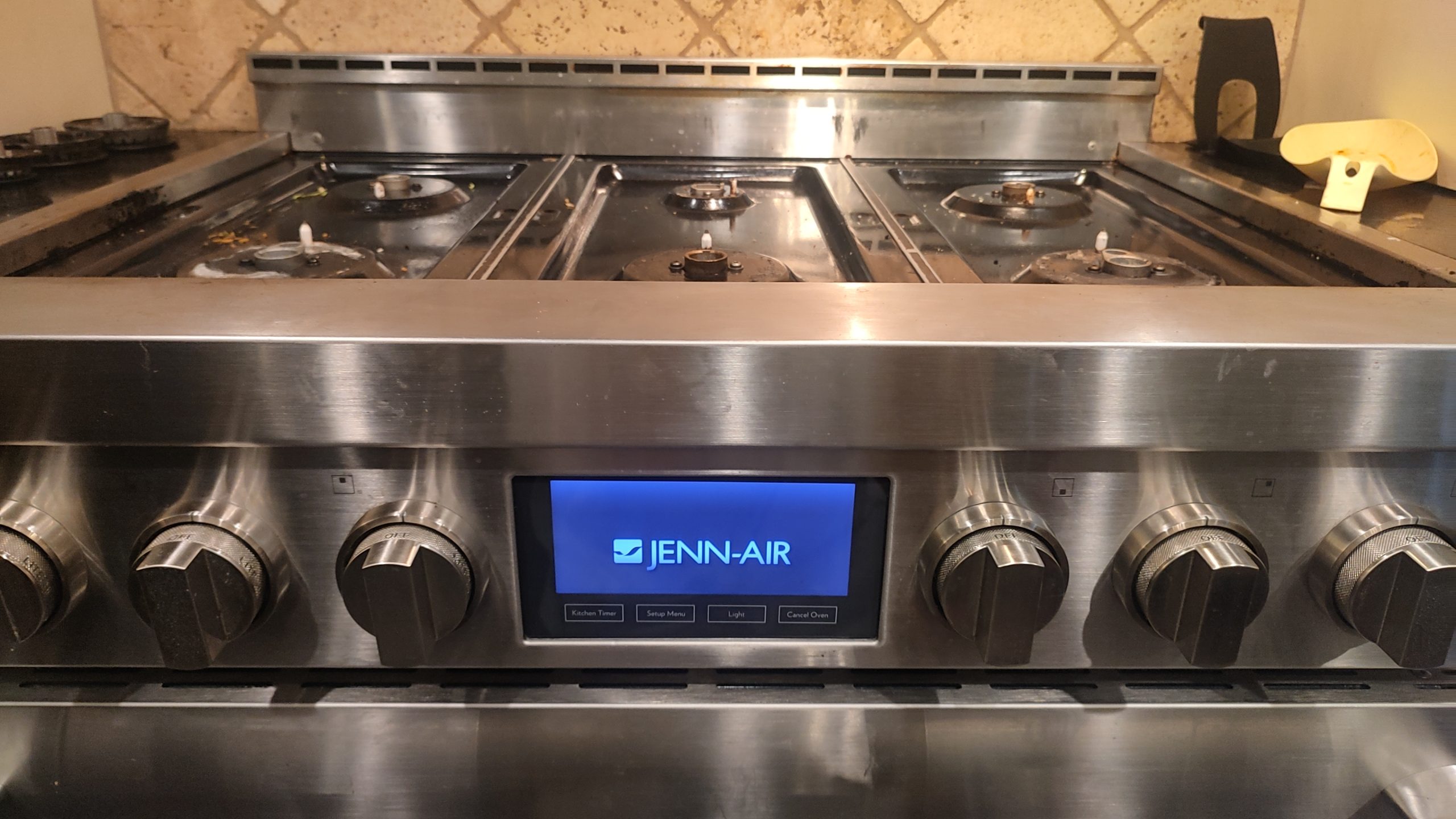 JennAir gas range with front control display and cooktop burners visible.