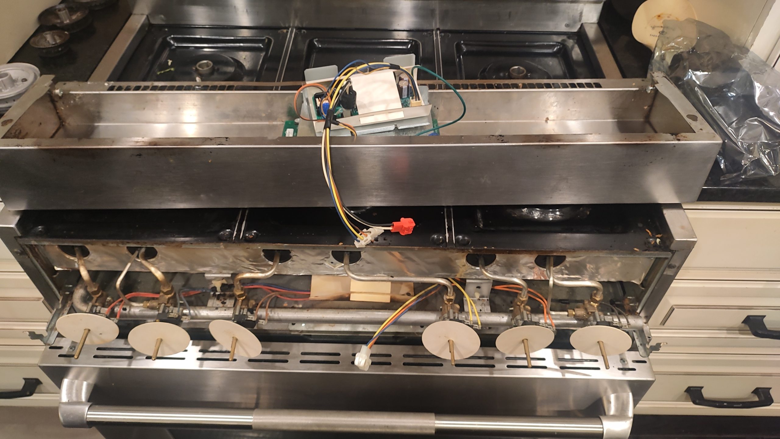 JennAir gas range with the front panel removed for low-voltage power supply board replacement.