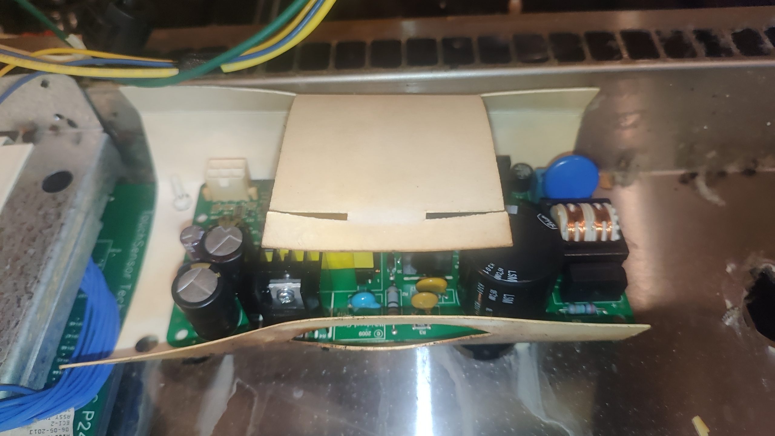 Low-voltage power supply board installed behind the front panel of a JennAir gas range.