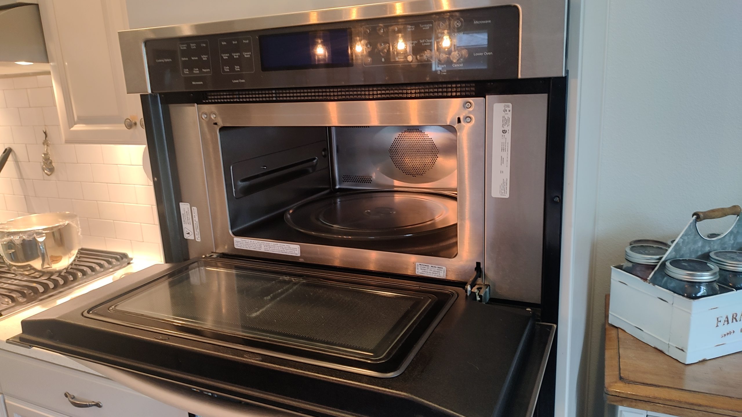 Open upper microwave door on a Whirlpool WOC97ES0ES02 wall oven combination before the door mechanism repair